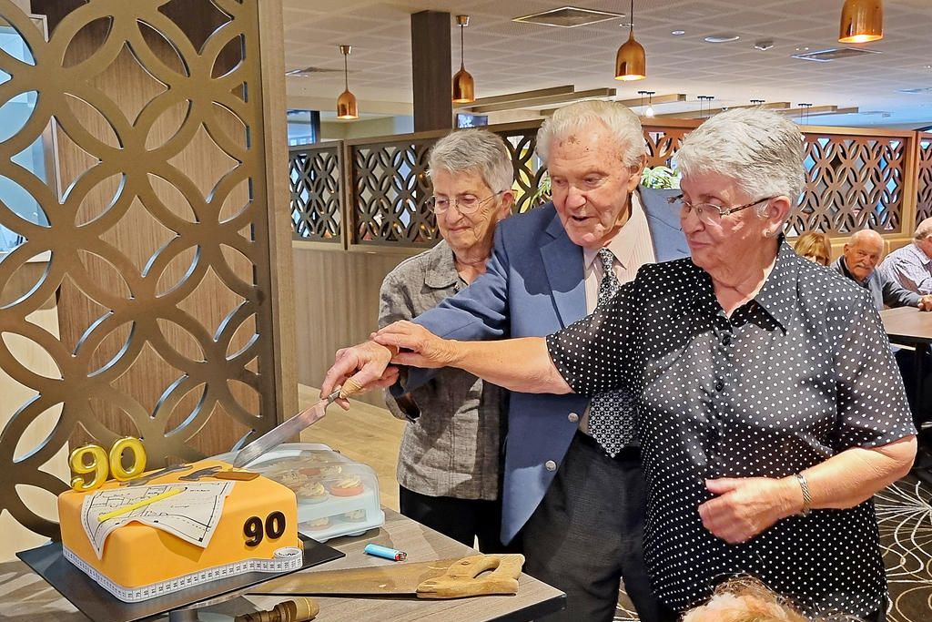Ian Ballinger cutting his 90th birthday cake with family on March 23.