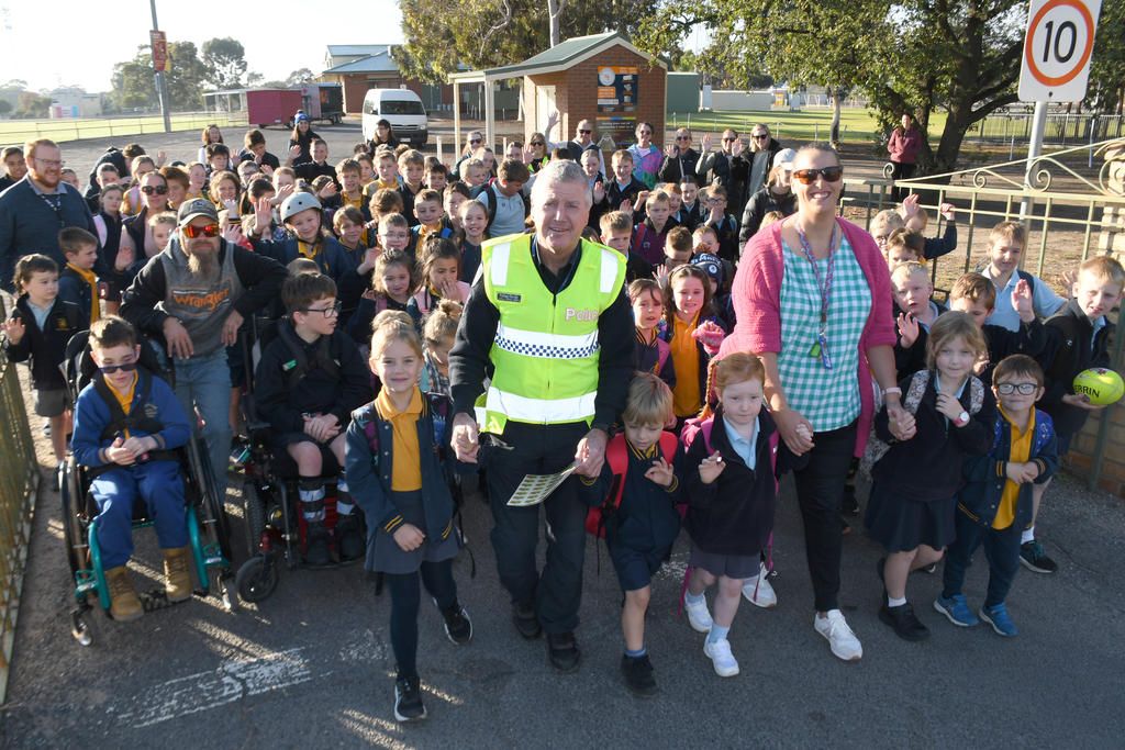 Warracknabeal Police LSC Peter Taylor joins teacher Victoria Wilken with the crowd of junior school students as they head off to 'Walk to School' last Friday morning from Anzac Park. Photo: DAVID WARD
