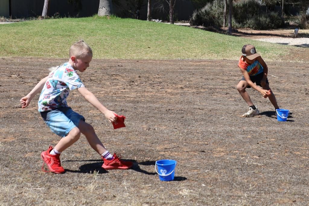 Kids in action during the bean bag bucket race. Photo: LES GRAETZ