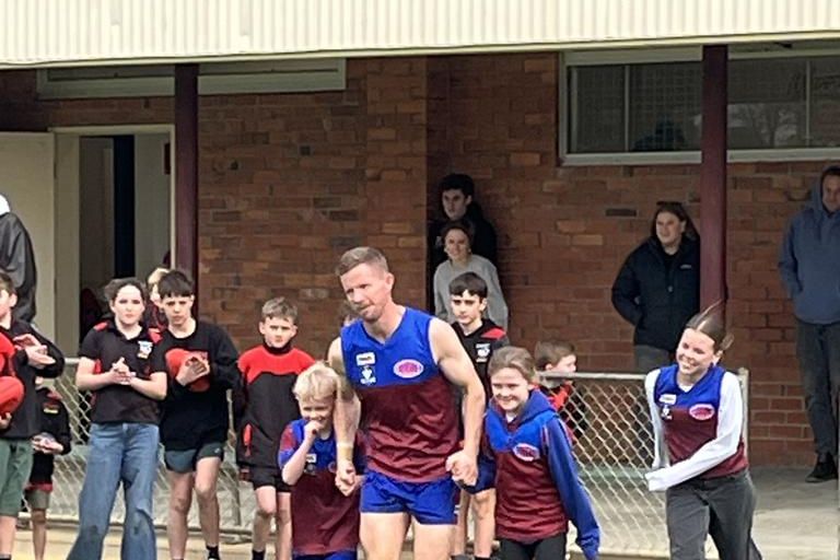 Brad Hartigan runs out onto the ground with his family.