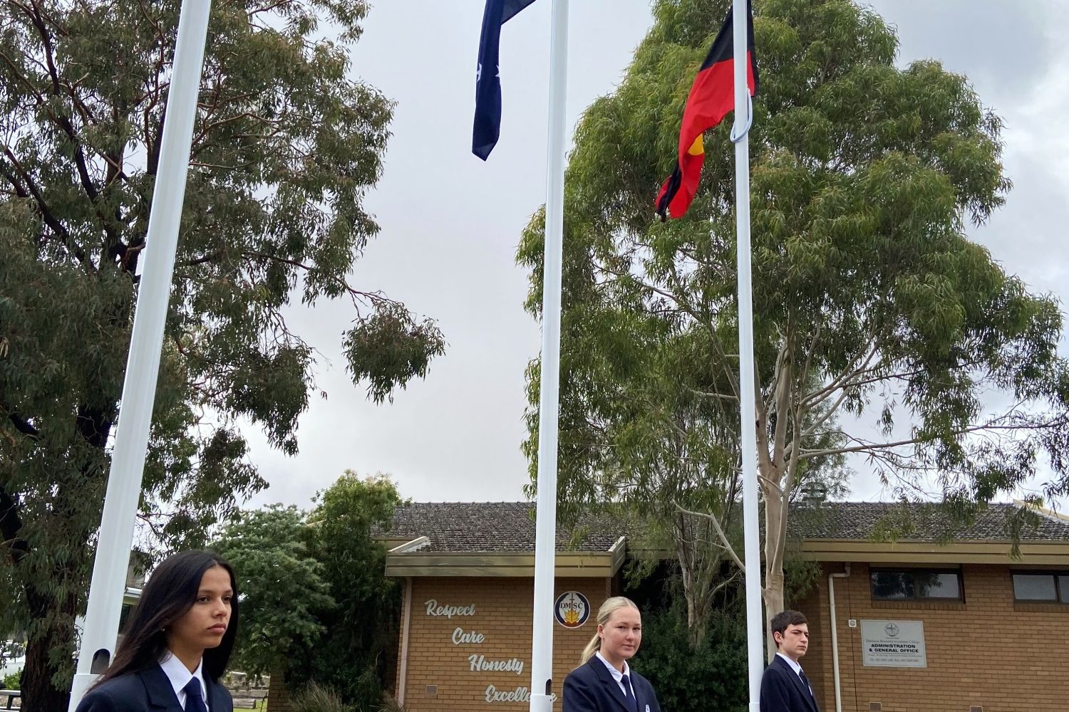 College captains Maryam Yahiat and Tilli Menzel, together with school council student representative and Koorie student Ethan Angel-Hands, take part in the flag-raising ceremony.