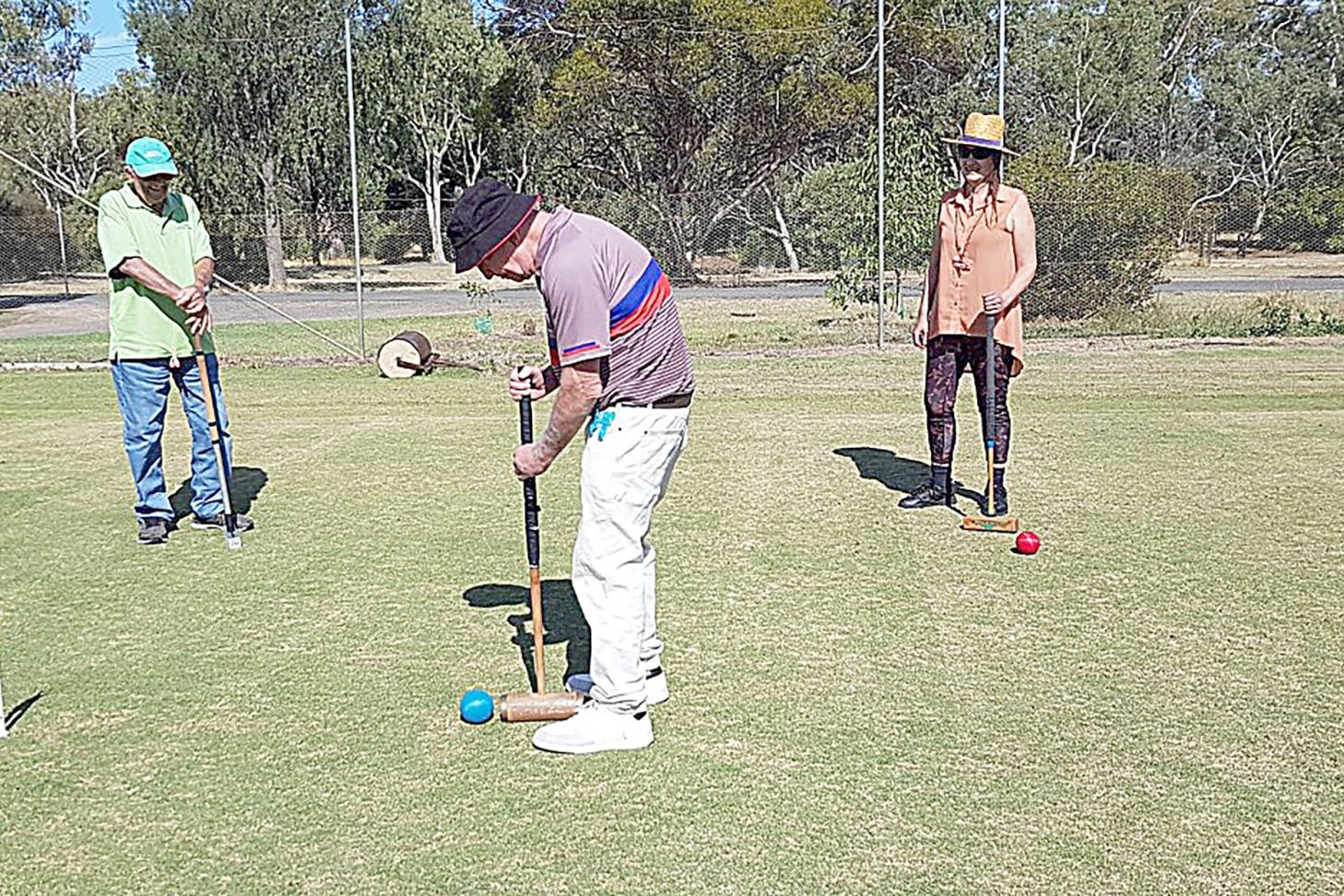 Brian Carleton, from Atherton, North Queensland lines up a shot, while John Lehmann and Linda Ceef watch