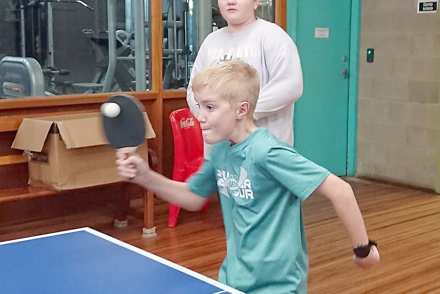Saturn's Zac is on the ball against his Pluto opponents under the watchful eye of teammate Zoe.