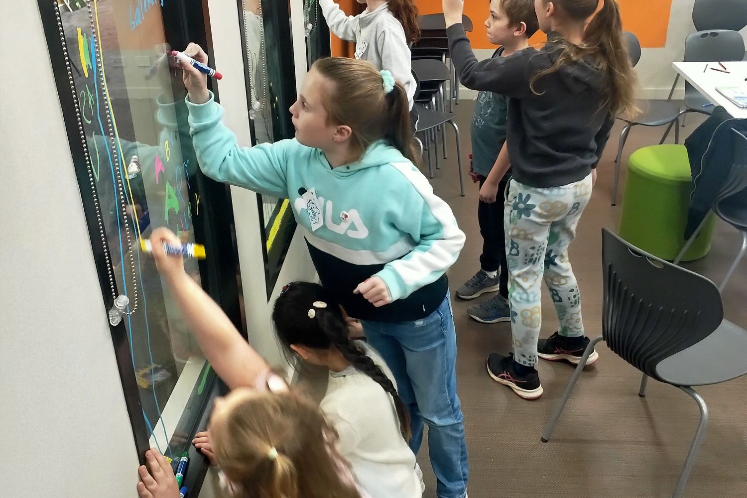 Youngsters use a gallery window as their canvas.