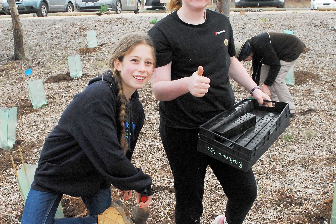 Annika Petschel and Lily Saul do an amazing job helping to clean up after the students planted creeping boobialla along slopes on the east side of Rainbow Lake