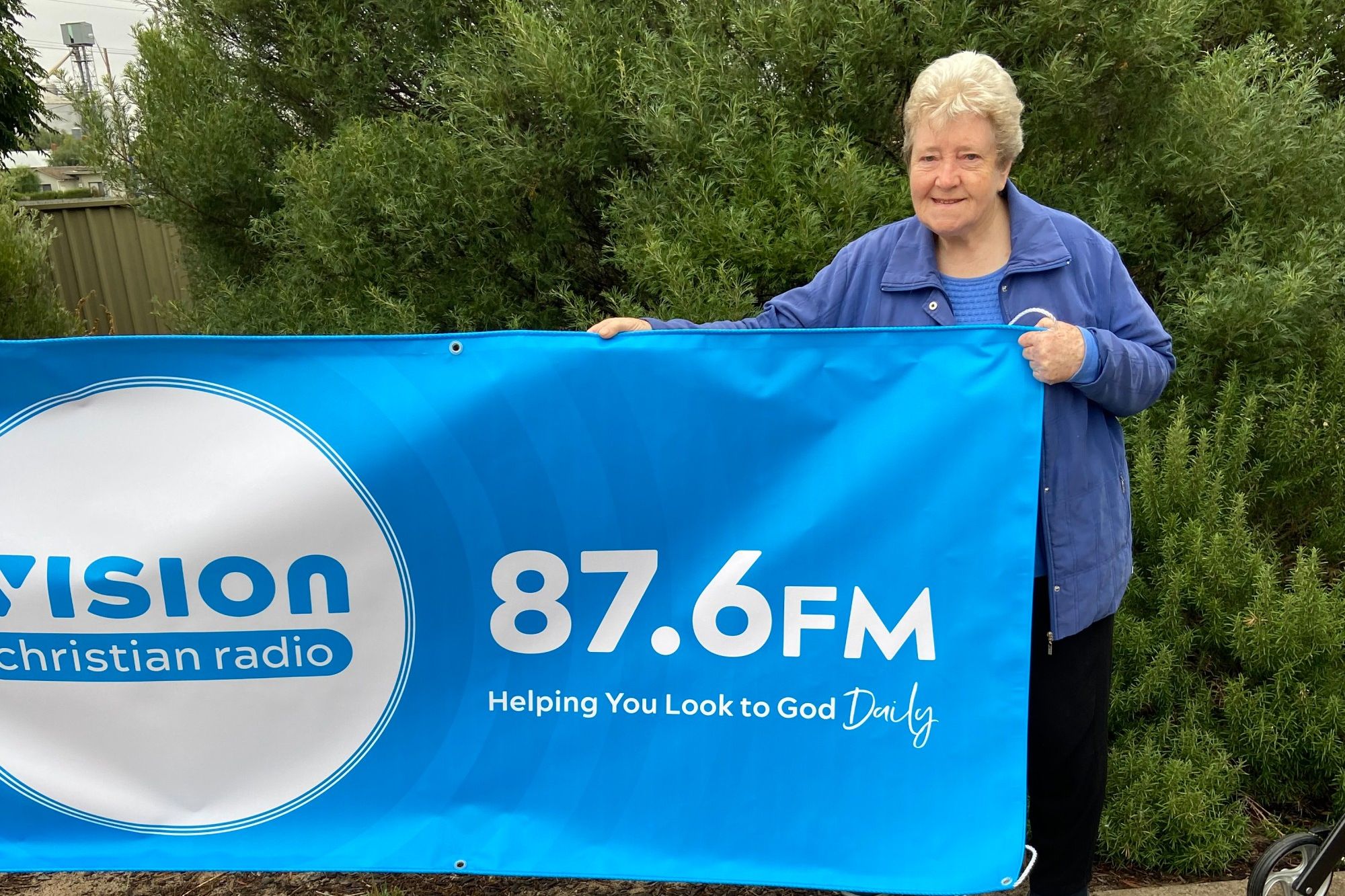 Gladys Schwarz displays Vision Radio Banner.
