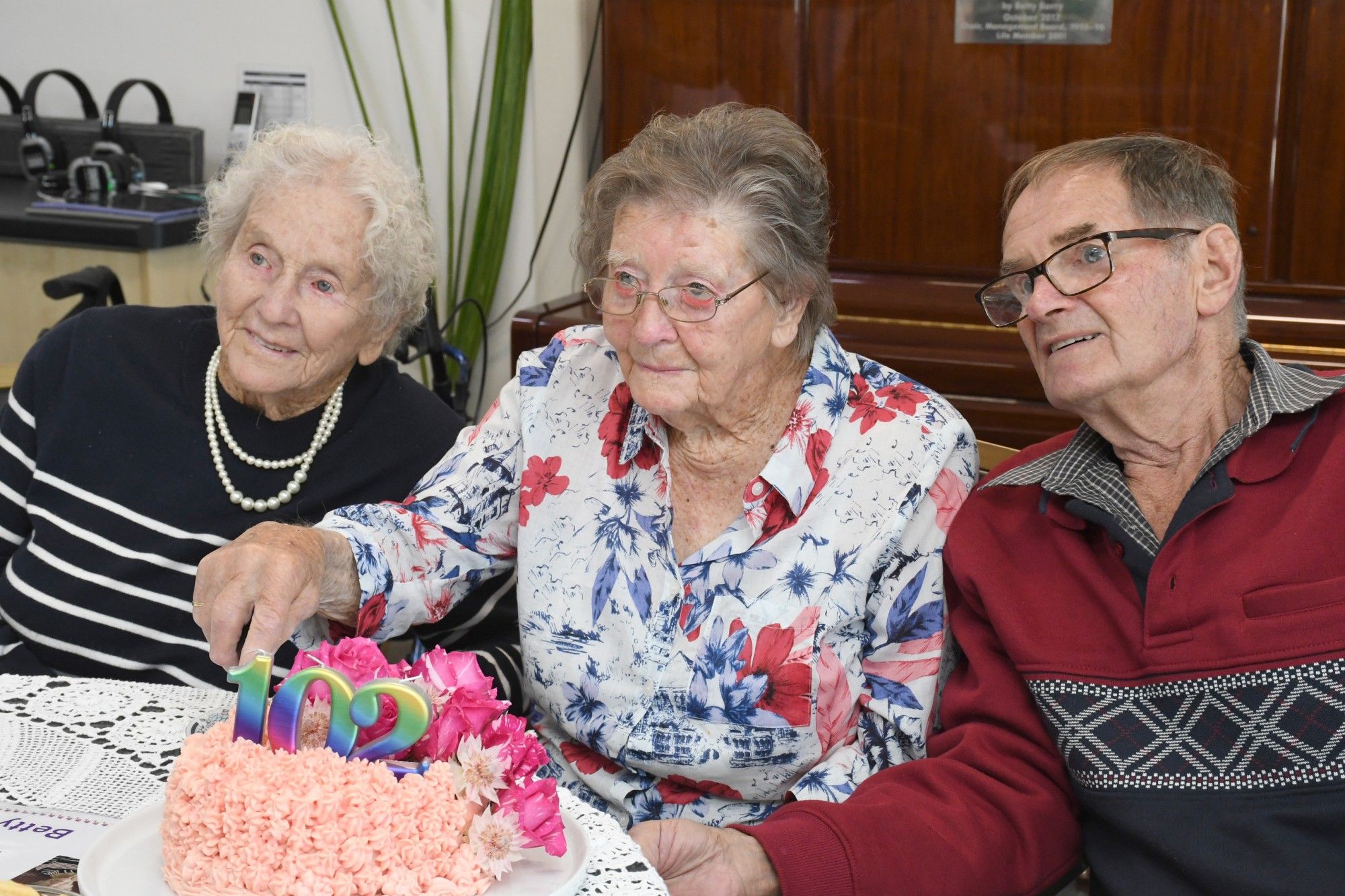 Betty Saunders cuts her birthday cake with sister Marg Northfield and son Lyal. Photo David Ward