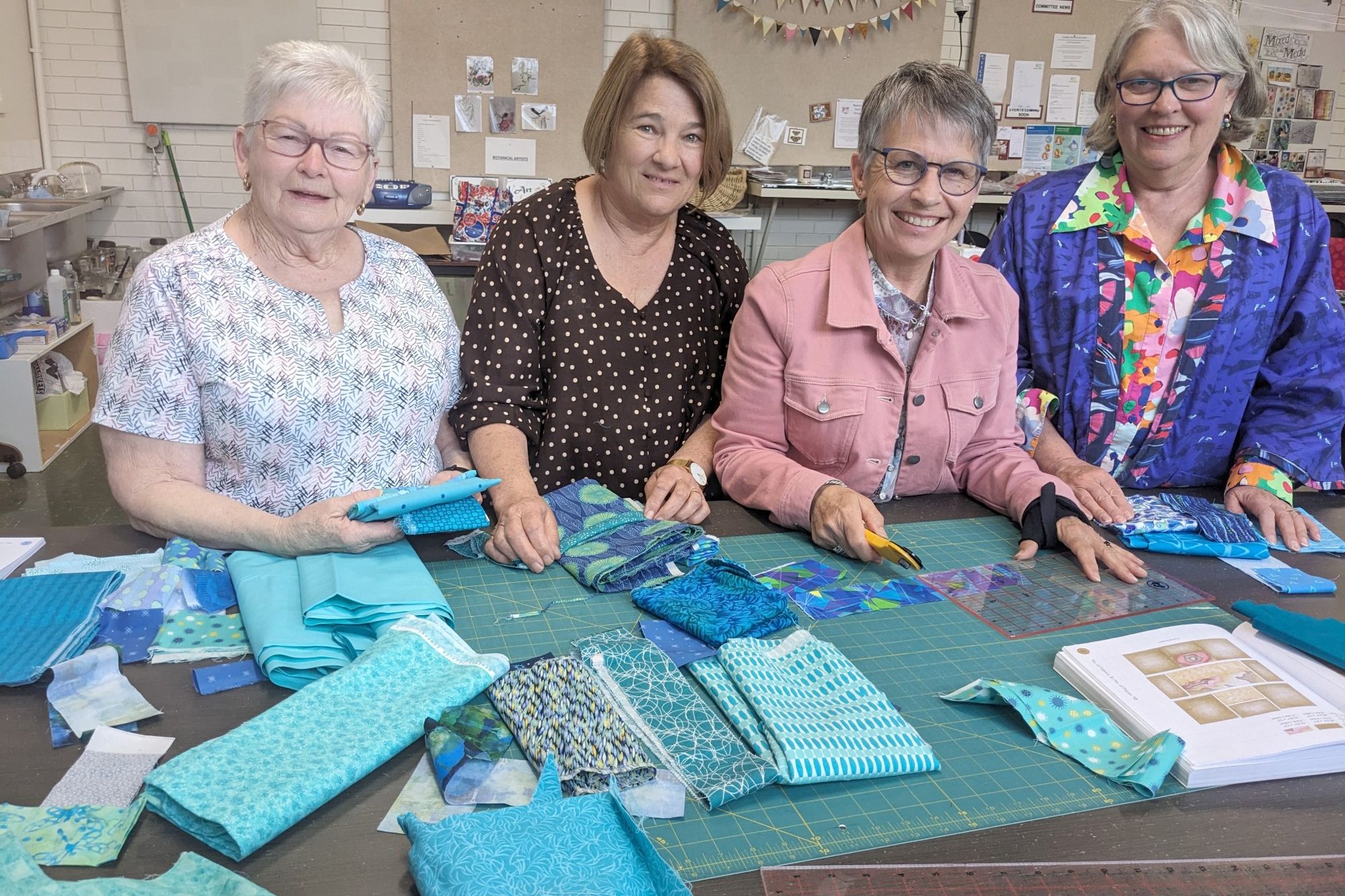 Faye Woodhart, Christine Gerdtz, Sally Lockwood and Isabelle Martin use the large table to cut quilt pieces for a joint-group quilt. Credit FAYE SMITH