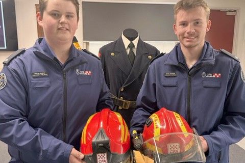 Firefighters and cousins Declan Whelan, 18, and Kynan Jonasson, 19, with fire helmets displayed among the memorabilia at the new station opening on Saturday.