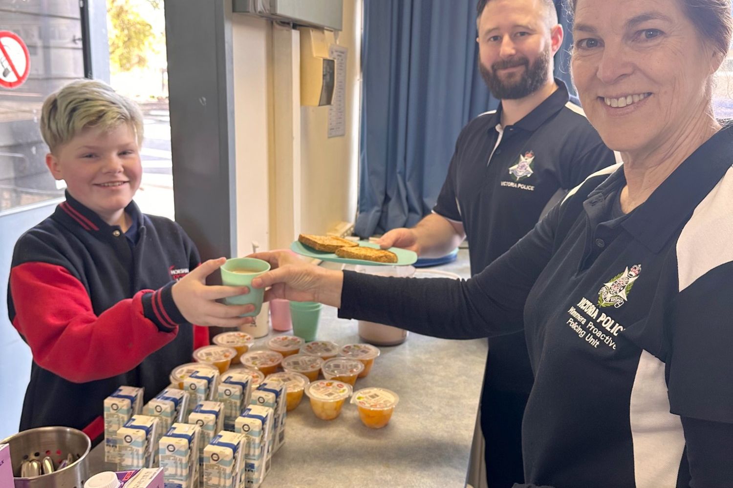 Leading Senior Constable Linda McLennan and Senior Constable David Hoffmann serve breakfast to Grade 6 student Ammy Wren.