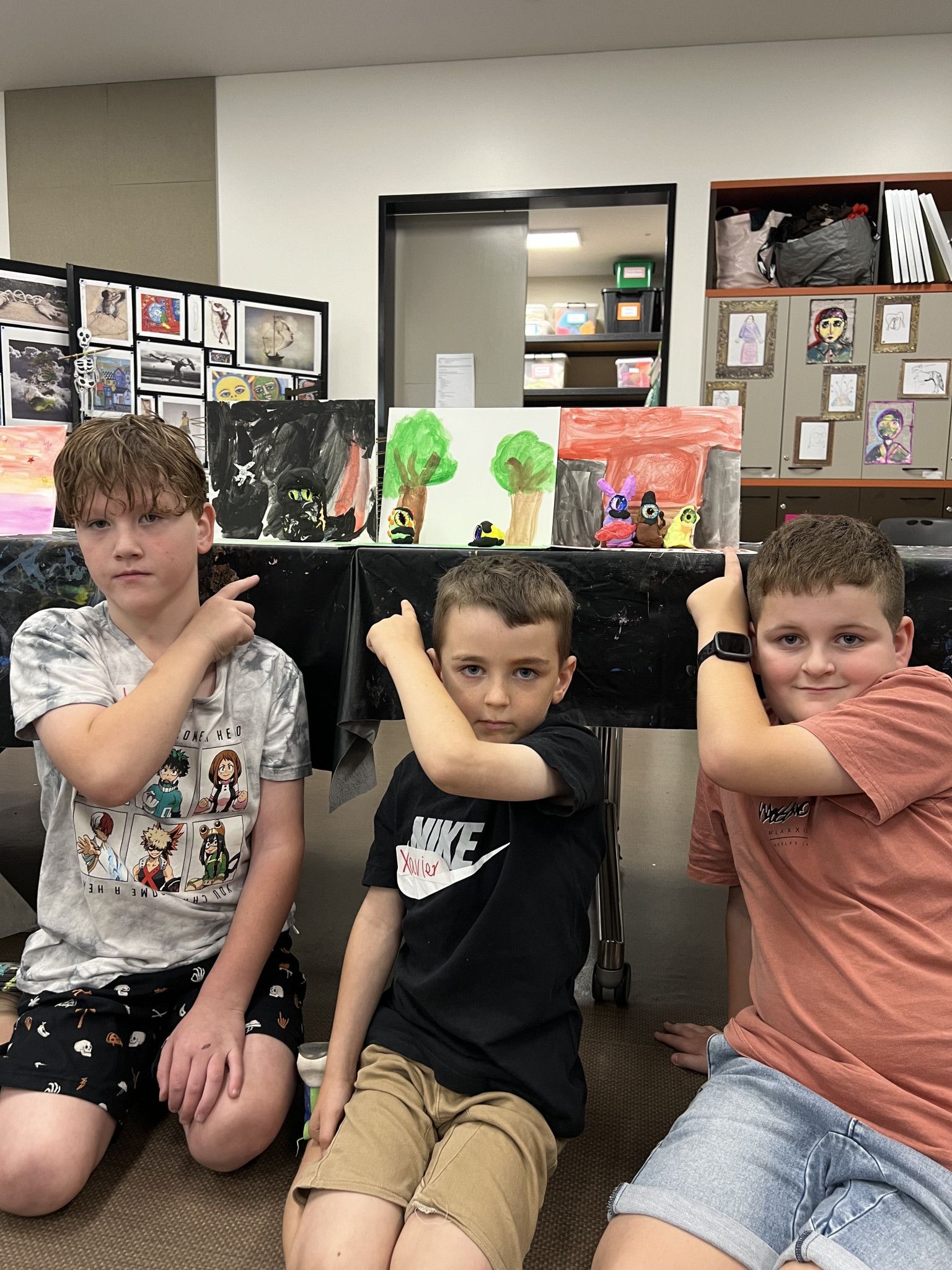 Local kids Jaxon, 7, Xavier, 7, and Alfie, 10, point out their final outcome after the Mini Monsters activity at Horsham Art Gallery.