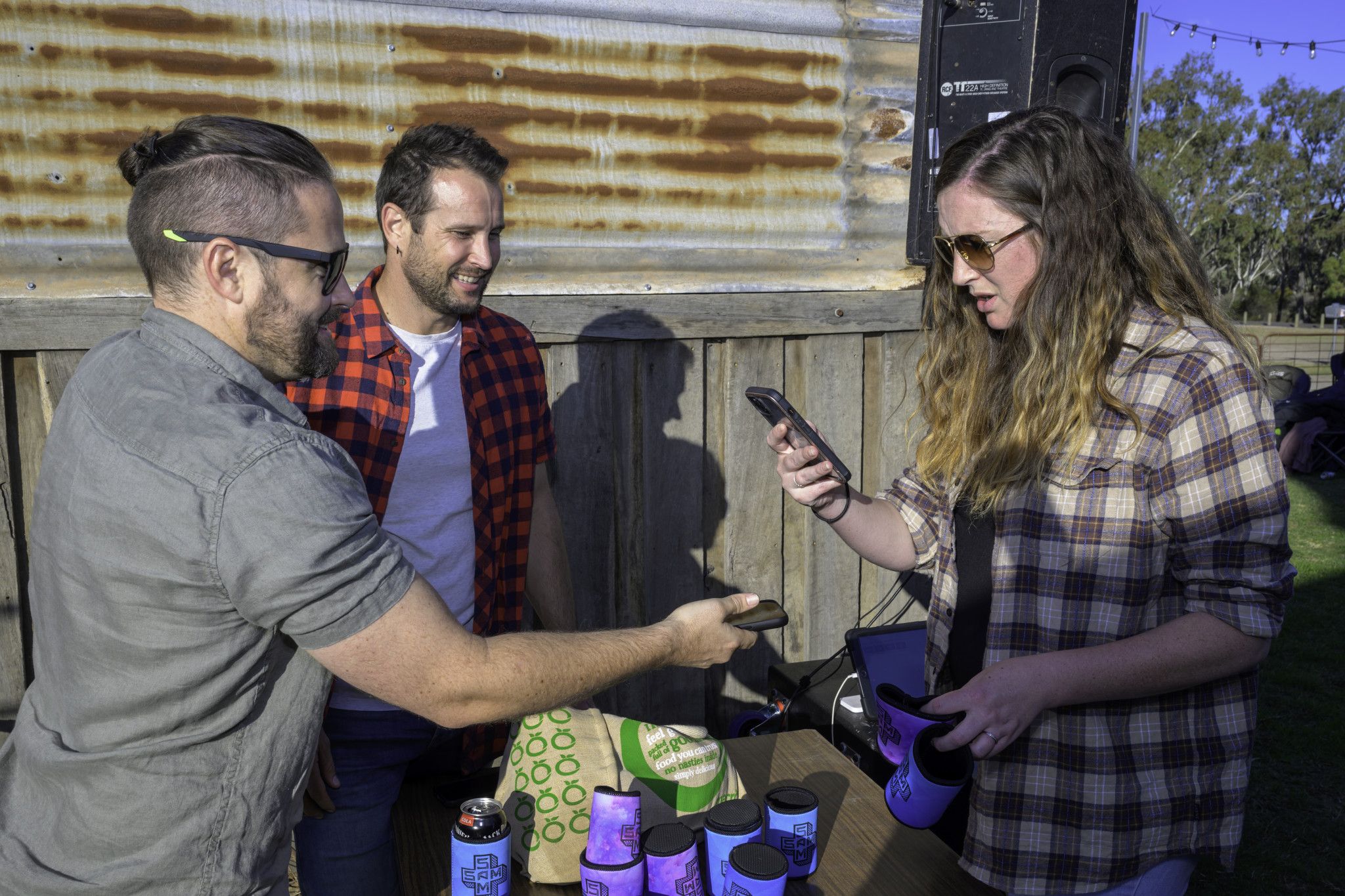 Performers, Sam Russell and Sam Ludeman selling some merchandise to Abi Rabone.