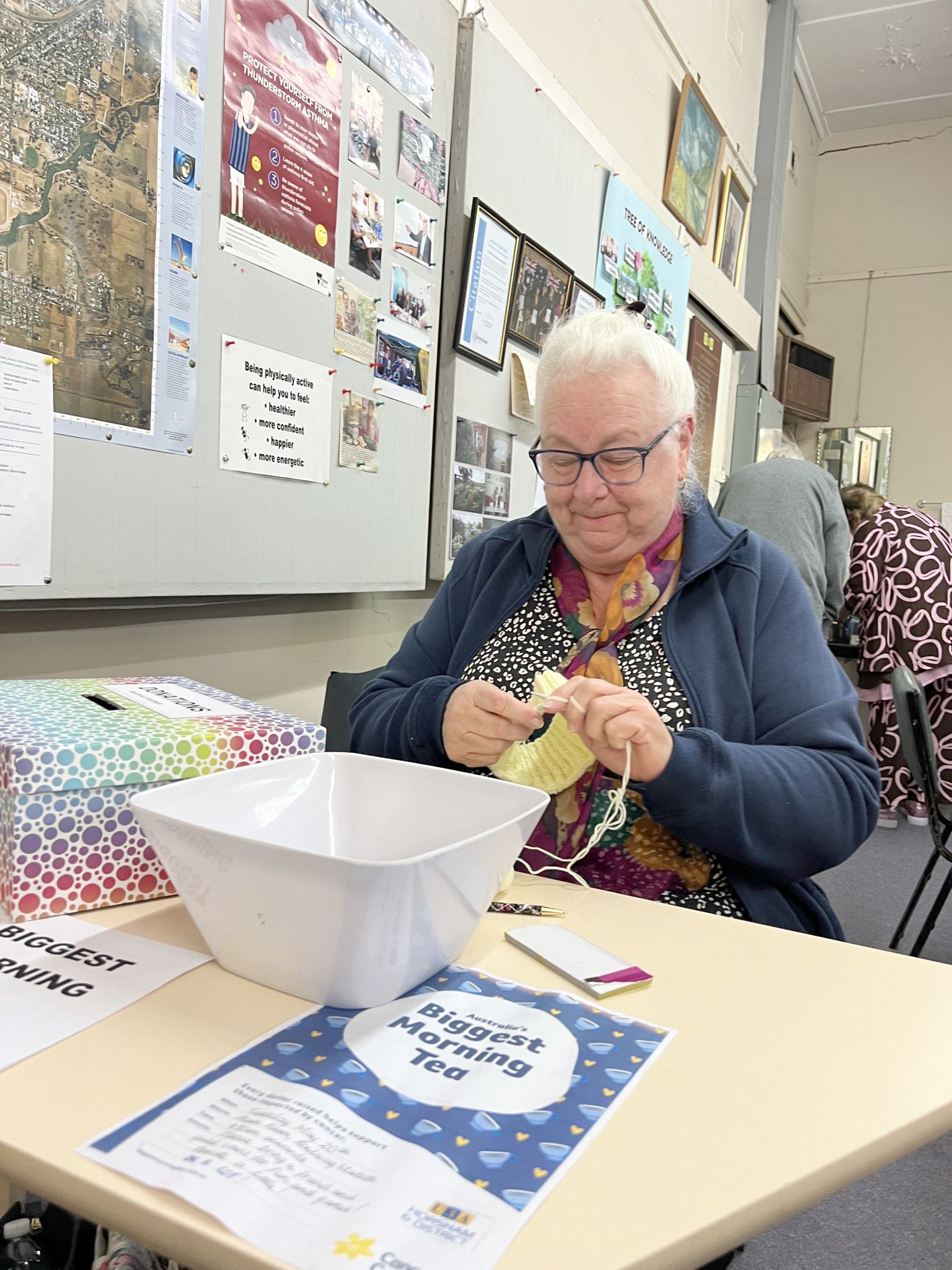 Margery Pannan selling door tickets while knitting.