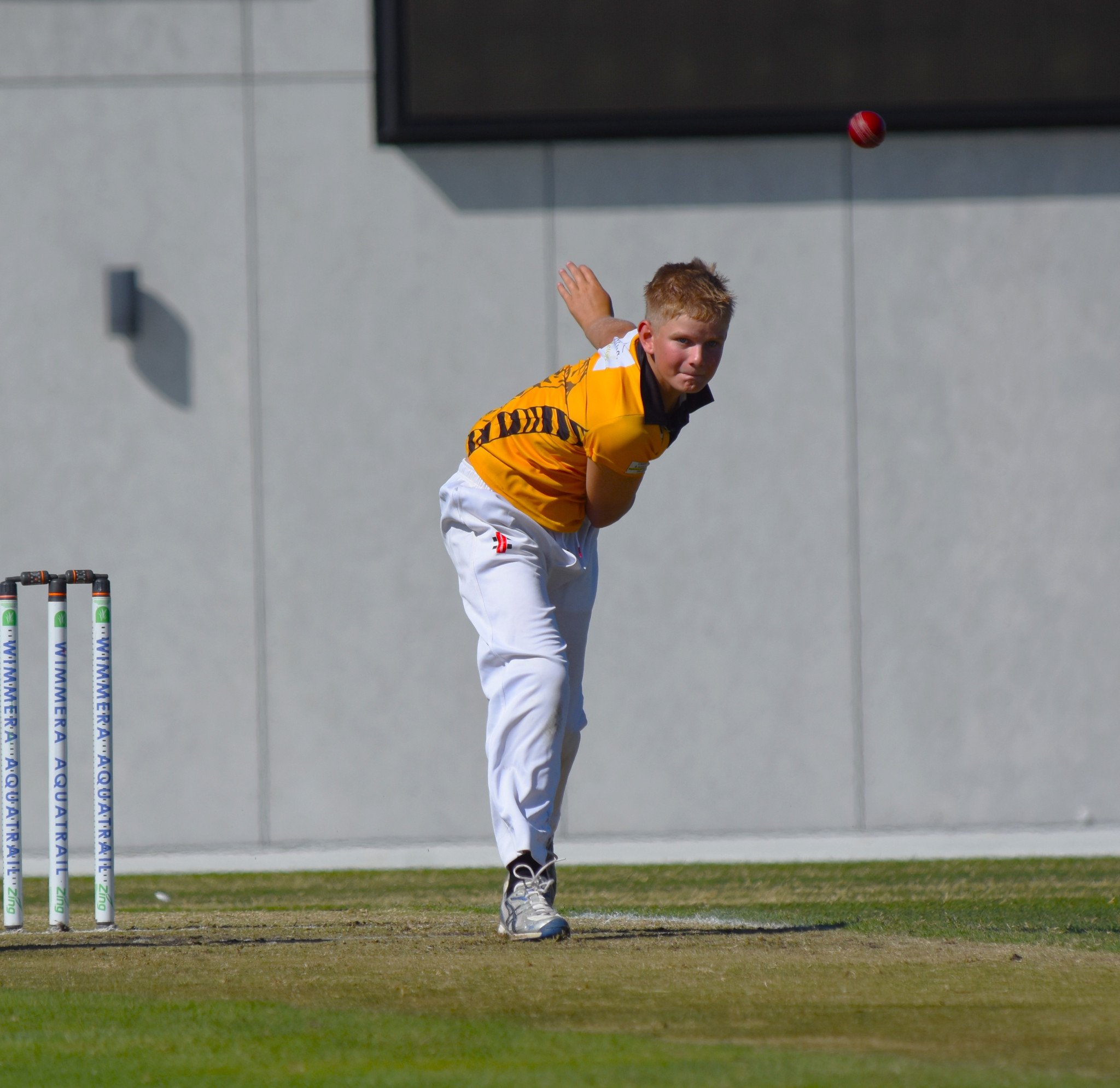 Lenny Clark tracks his delivery during the under 14 grand final.