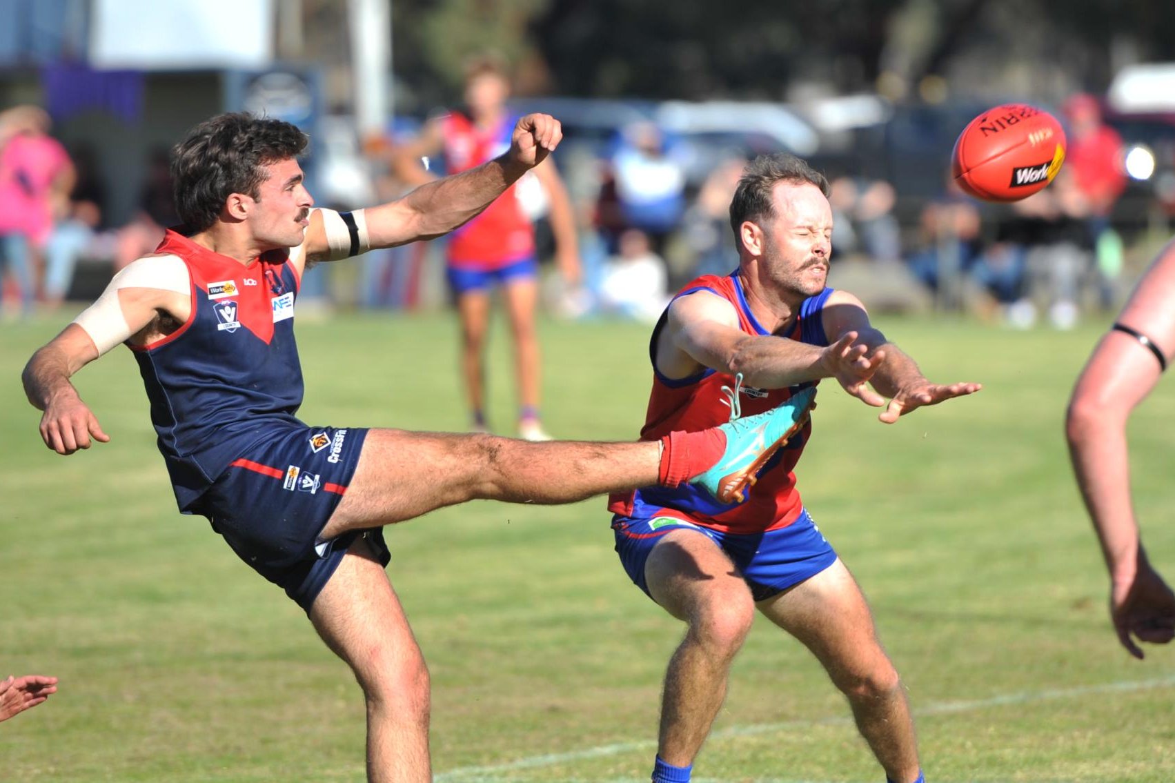 Despite the pressure from Kalkee's Lous Papst, Laharum's Pat Lattanzio gets his kick away in round two of the HDFNL at Cameron Oval. Picture by John Hall