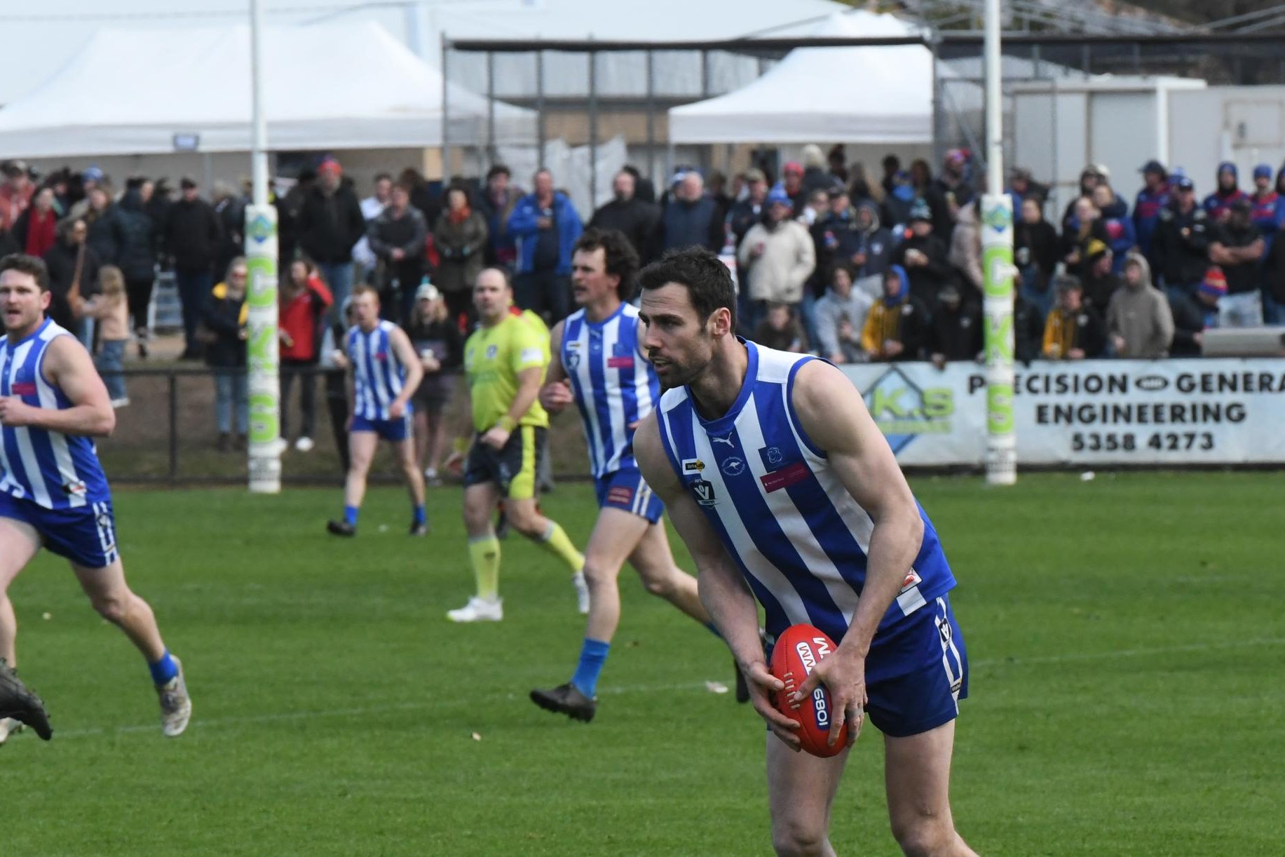 A crowd of many watches on from the hill as Harrow Balmoral's Michael Close lines up a kick in the 2024 HDFNL grand final at Stawell's North Park. Picture by Lucas Holmes