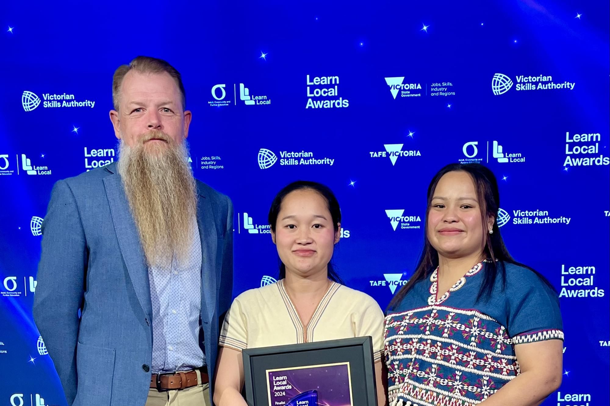 Centre for Participation chief executive Robbie Millar, Ro Allen Award recipient Paw Say Paw and KLu Say Say the Victorian government's Learn Local awards.