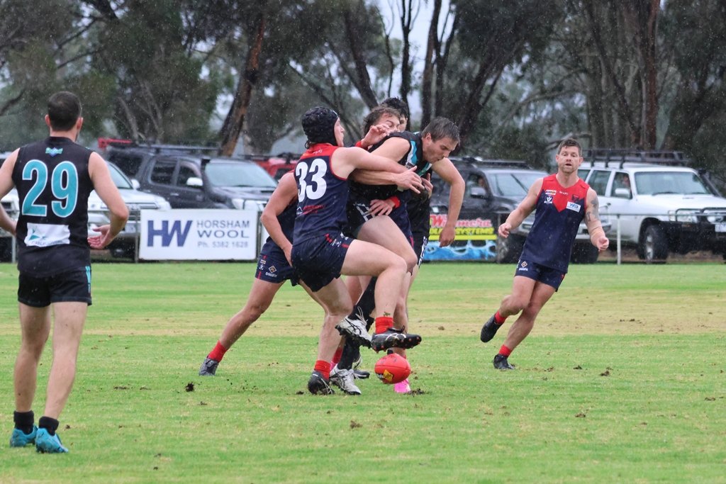 Laharum's Josh Hutchinson tackles Swifts' Brett Hargreaves during their rain-soaked round-six encounter at Cameron Oval. The Demons prevailed 6.19 (55) to 3.10 (28).