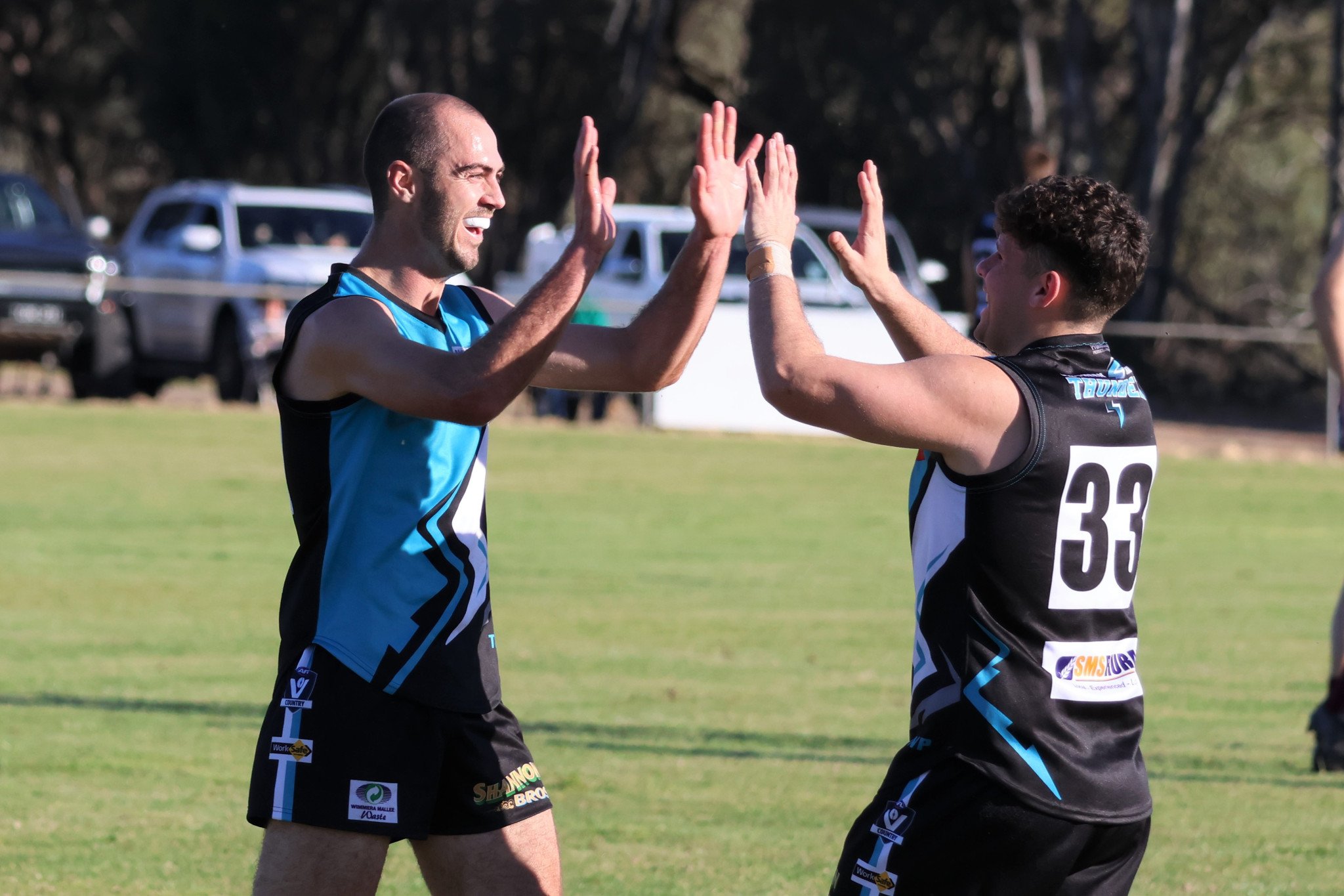 Thunder's Lou White celebrates kicking a goal with Tom Clarke. PHOTO: LES GRAETZ