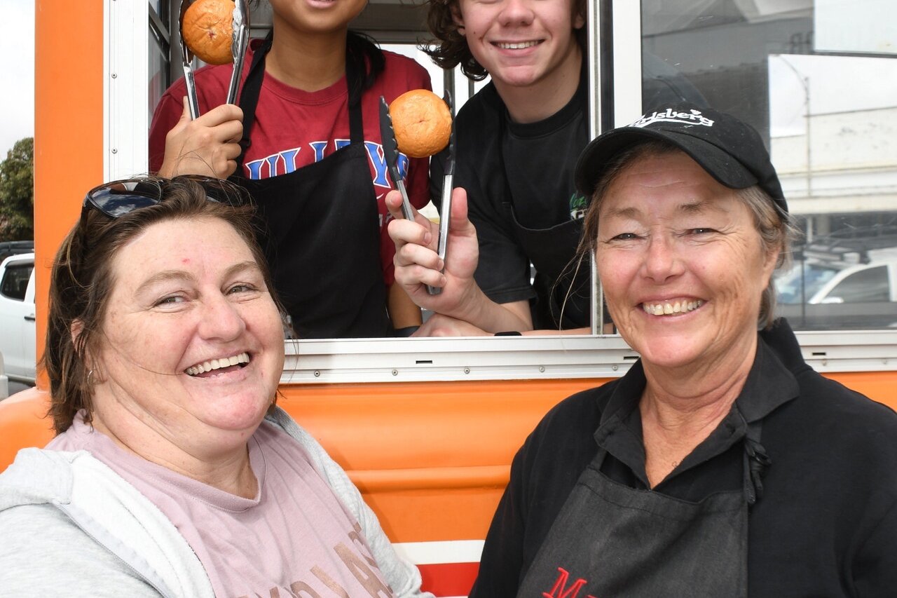 Lynda Jorgenson hands over the apron to the new Donut Van owner Wenda Billman at the Warracknabeal Market last Saturday. Wenda&rsquo;s son Jai, and friend Alexi Bebero had a training session at the market and will be operating the van in future. Photo: DAVID WARD