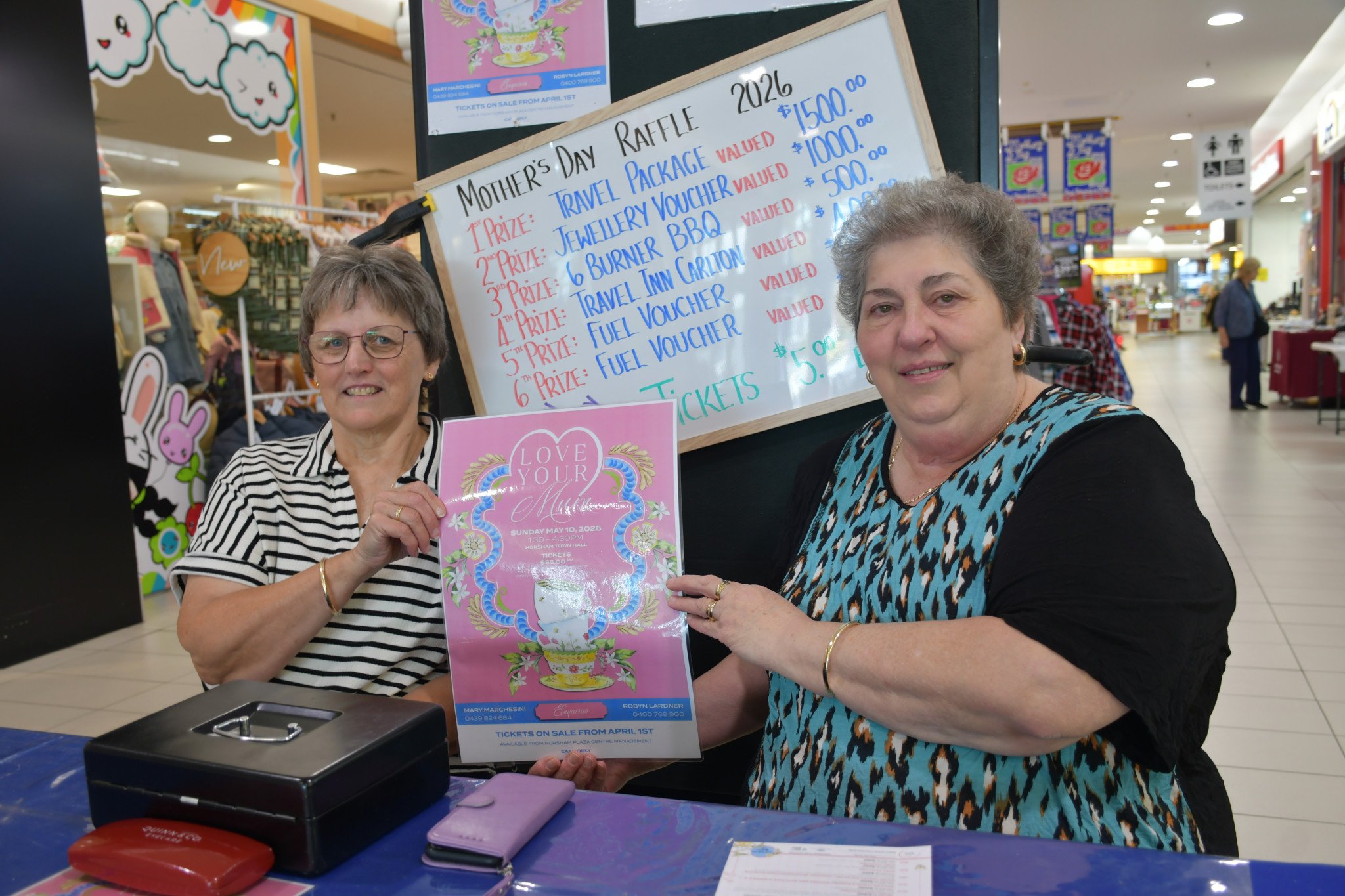 Local volunteers Pam Mannell and Mary Marchesini are selling $5 raffle tickets at the Horsham Plaza for the upcoming Mother's Day event, "Love Your Mum," at the Horsham Town Hall on May 10.