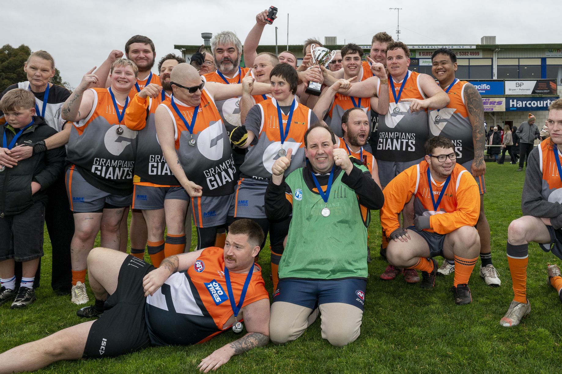 The premiership-winning Grampians Giants teams celebrate after their grand final victory over South Warrnambool.