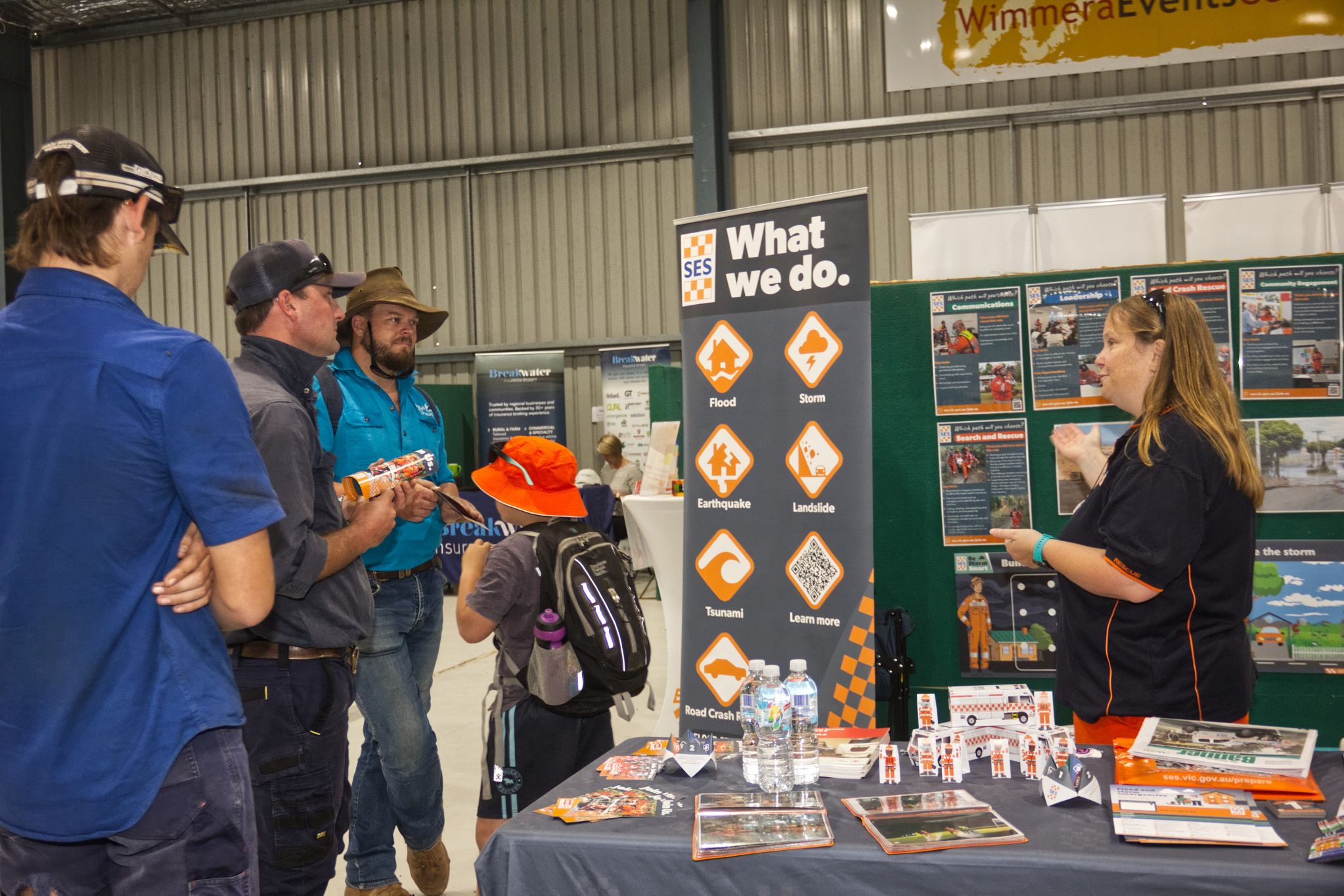 Reaching out to inform about disaster preparedness and recruitment at Wimmera Machinery Field Days to Bryce Hudson, Nathan Blomeley, Ashley Warby and Riley Blomeley, 9, is SES community engagement officer, Crystal Sanders.