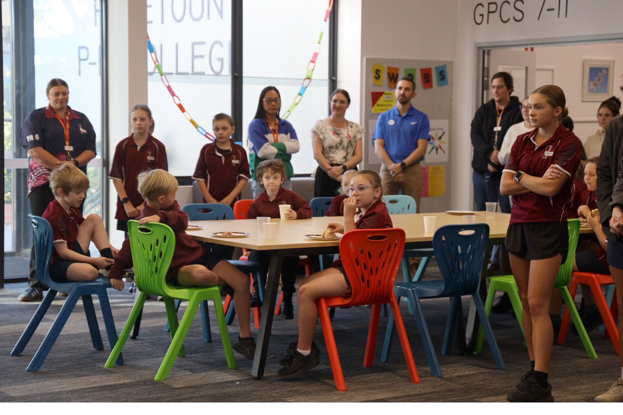 Lilly (standing on the right), listening to the school council president, Bridget Williams, addressing guests at the school's Big Breakfast.
