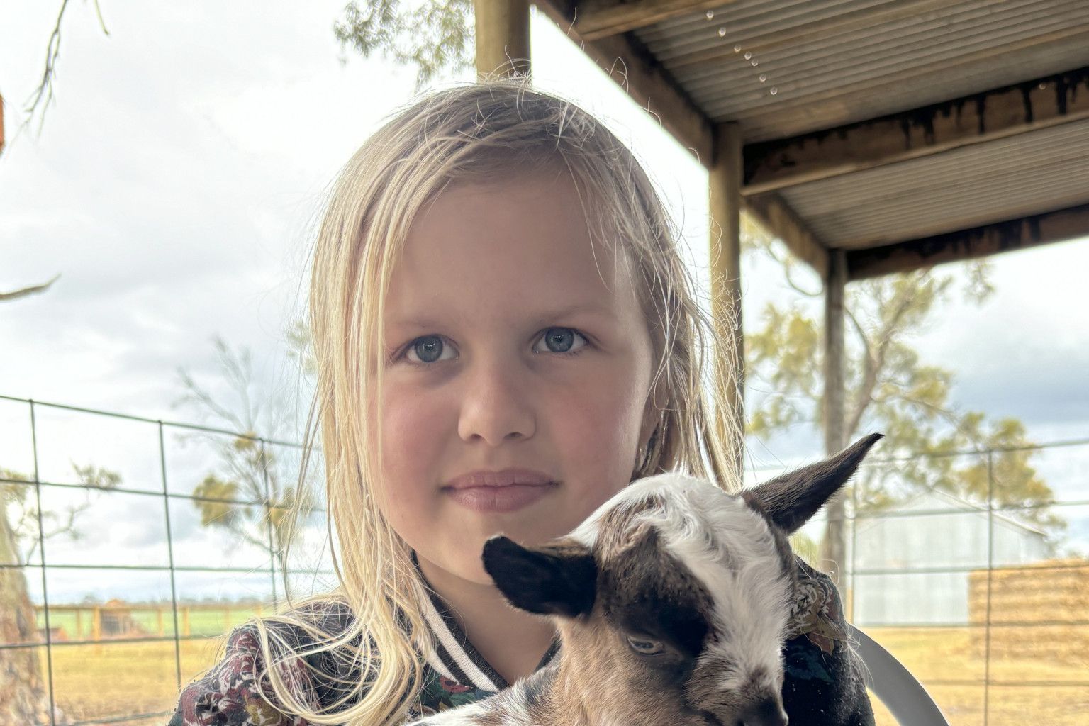 Kiani, 8, enjoys the company of the baby goat.