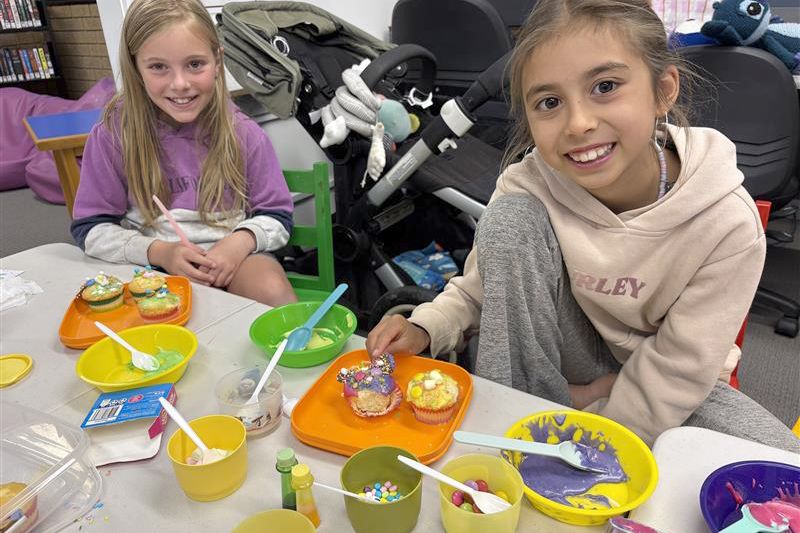 Elaine and Emma decorating cupcakes.