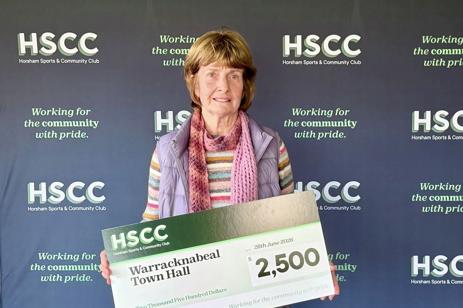 Secretary of the Town Hall Committee, Jenny Taylor, receives the mock cheque for $2500. Photo credit: SUPPLIED