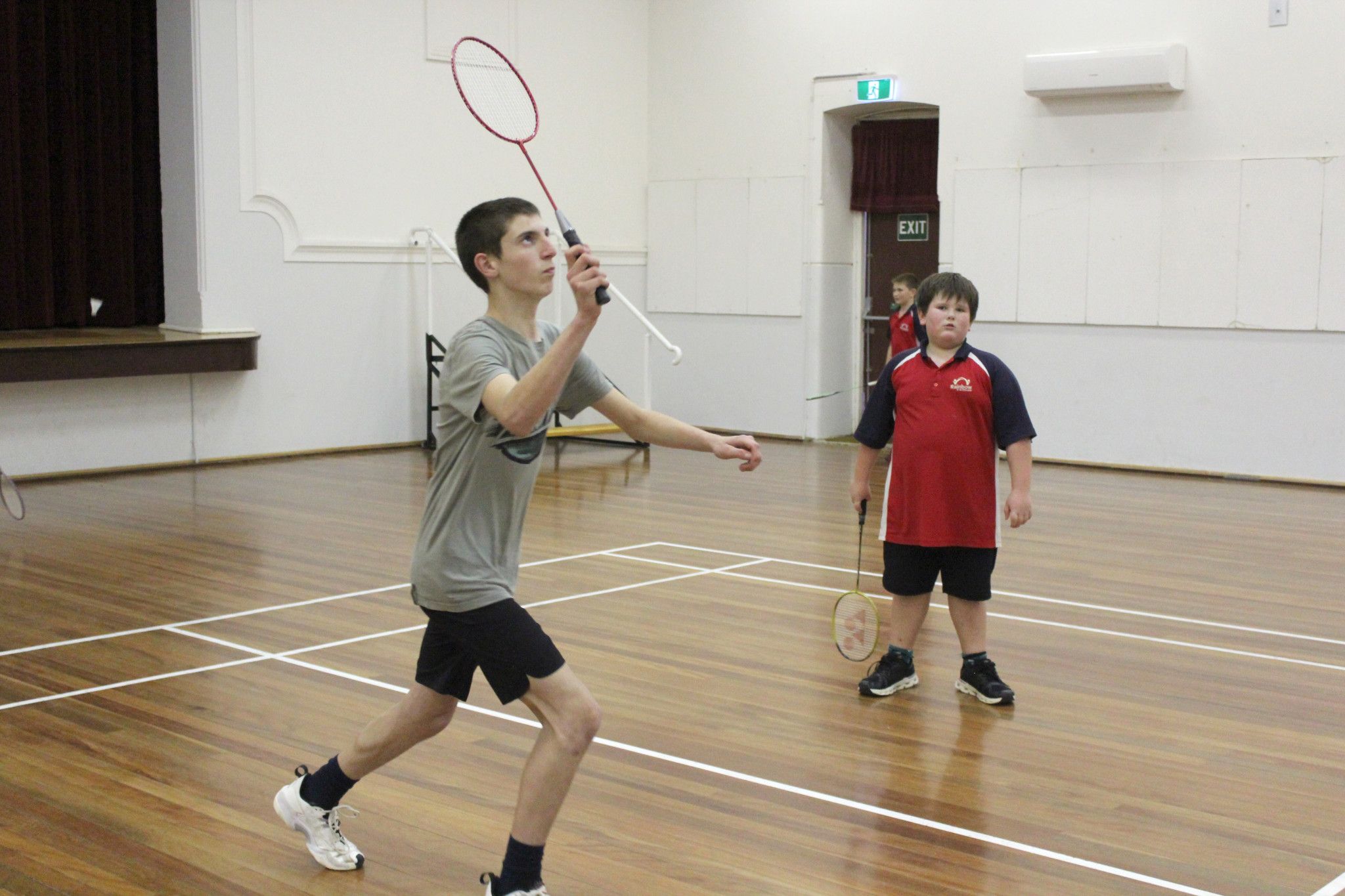 Tyler Webb lines up the shuttle, with playing partner Cooper Clugston looking on.