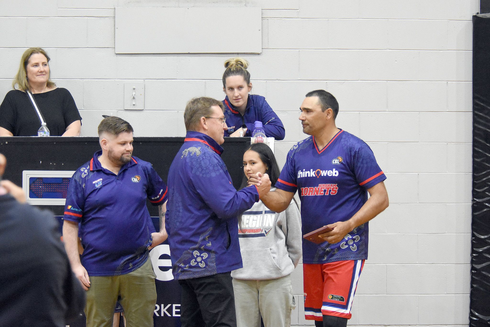 Playing his 150th game, Damien Skurrie receives his accolade from coach Scott Benbow.