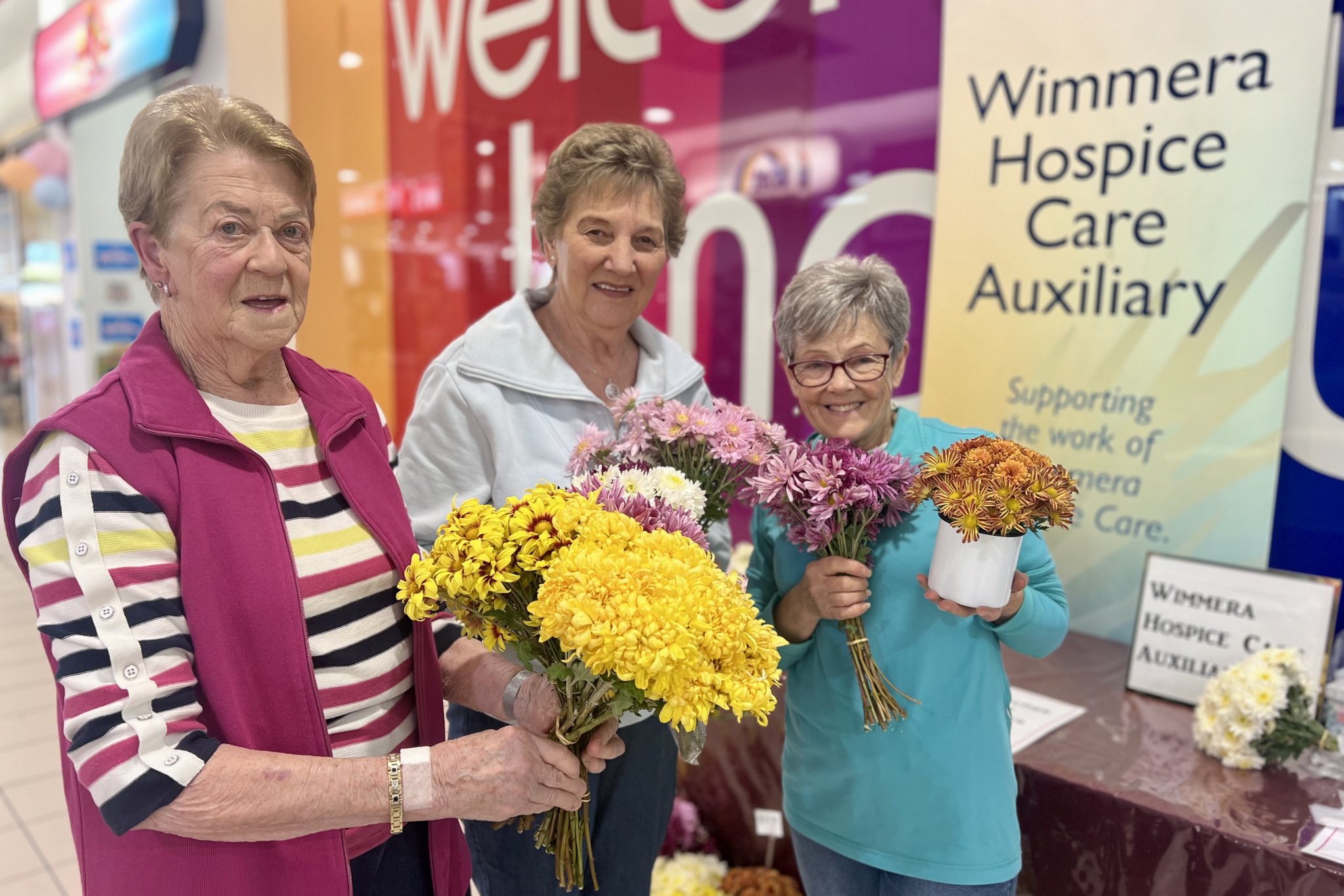 Wimmera Hospic Care Auxiliary volunteers Denise Mackenzie, Marion Seater, and Lea Crammond sold Chrysanthemum Flowers for Mother's Day last week in Horsham Plaza to raise money for their group. Photo: TAYYAAB MASROOR
