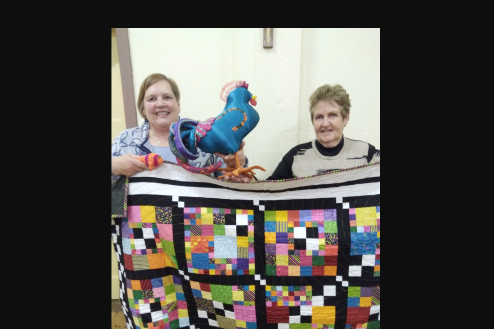 Pam Clugston and Elaine Nitshcke with bright and beautiful works of art, ready for display.