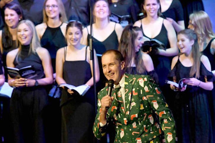 Pastor Simon Risson, dressed in a Christmas suit, MCs a Horsham Carols by Candlelight service in May Park.