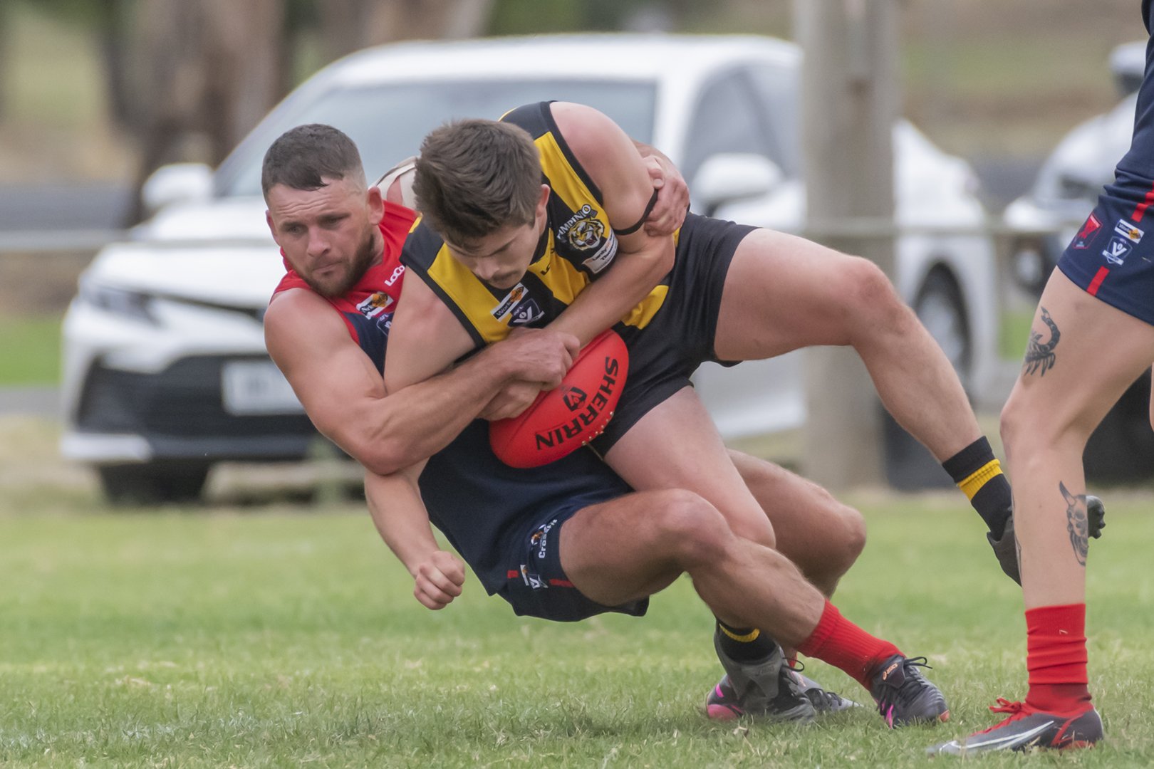 Demons co-coach Robbie Miller tackles Pimpinio's Charlie Gardner in round one.